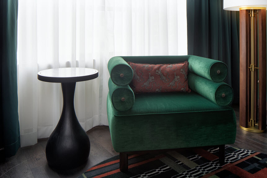 a green chair next to a black table