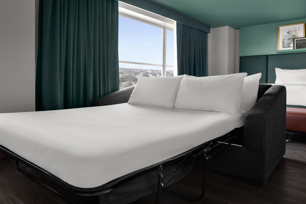 a bed with white sheets and a window